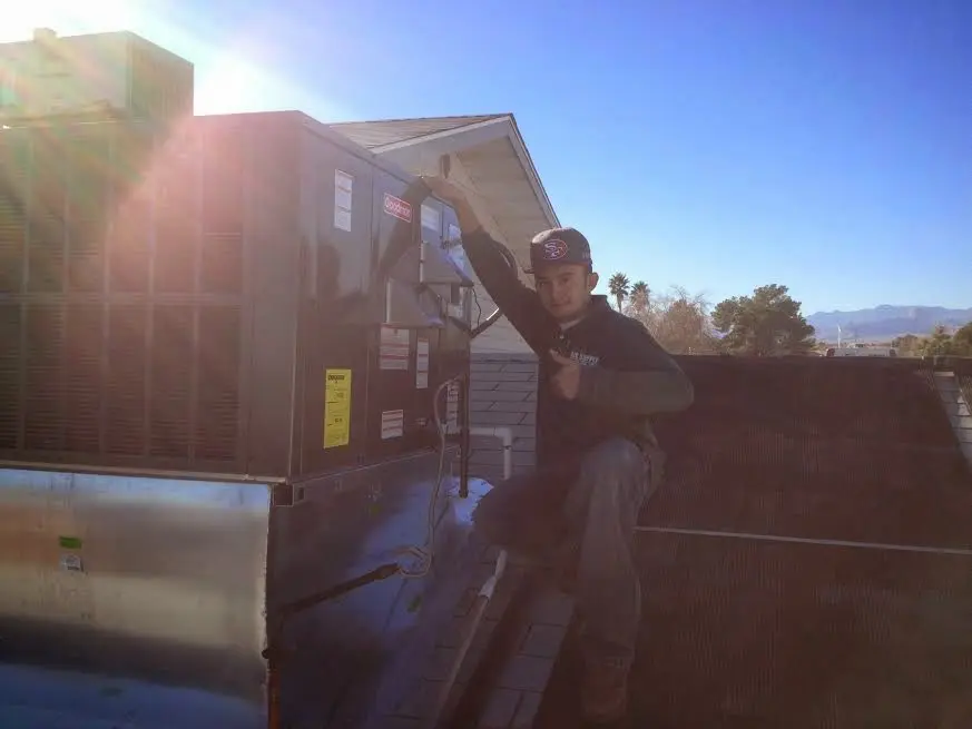 HVAC technician performing Heat Pump Repair on a rooftop unit in Vacaville